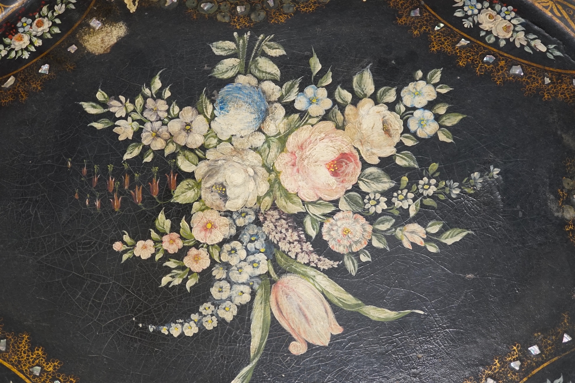 An oval papier mache tray with abalone inlay, hand painted with roses, 75cm wide. Condition - fair